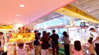 İnsanlar Bandung Alışveriş Merkezi 'nde 10 Ağustos 2025' te arkadaşlarıyla ve aileleriyle hevesle pençe makineleri oynuyorlar..