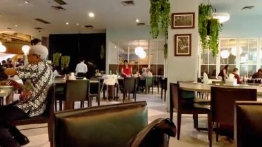 Bandung 'daki hareketli bir restoranın yüksek kaliteli 4K görüntüleri. Garsonlar müşterilerin siparişleriyle meşgul. Bandung 21 Ağustos 2025