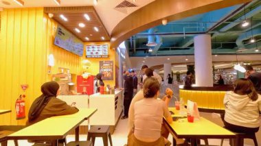 Bandung şehrindeki modern bir restoranın hareketli atmosferinde bir sürü müşteri geliyor ve garsonlar siparişlerle meşgul. Bandung 8 Temmuz 2025