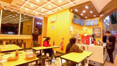 Bandung şehrindeki modern bir restoranın hareketli atmosferinde bir sürü müşteri geliyor ve garsonlar siparişlerle meşgul. Bandung 8 Temmuz 2025