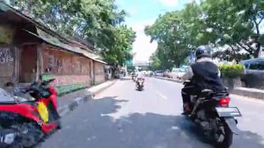 Ağır motosiklet akışının ve metropol bölgesinde gündüz vakti hareket eden arabaların yer aldığı 4K klibi, Bandung, Batı Java, Endonezya 5 Nisan 2025.