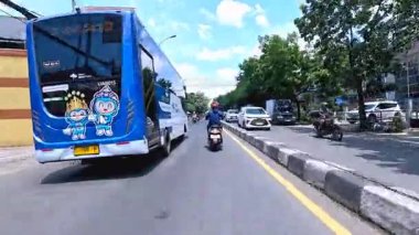 Ağır motosiklet akışının ve metropol bölgesinde gündüz vakti hareket eden arabaların yer aldığı 4K klibi, Bandung, Batı Java, Endonezya 5 Nisan 2025.