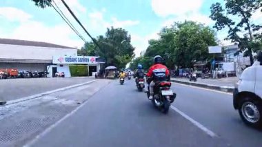 Ağır motosiklet akışının ve metropol bölgesinde gündüz vakti hareket eden arabaların yer aldığı 4K klibi, Bandung, Batı Java, Endonezya 5 Nisan 2025.