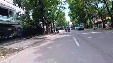 Ağır motosiklet akışının ve metropol bölgesinde gündüz vakti hareket eden arabaların yer aldığı 4K klibi, Bandung, Batı Java, Endonezya 5 Nisan 2025.