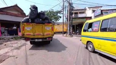 Kalabalık şehir manzarasını gösteren 4K görüntüleri açık bir günde birçok insanın motosiklet sürdüğü ve araba sürdüğü, Bandung, West Java, Endonezya 5 Nisan 2025.