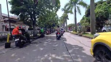 Kalabalık şehir manzarasını gösteren 4K görüntüleri açık bir günde birçok insanın motosiklet sürdüğü ve araba sürdüğü, Bandung, West Java, Endonezya 5 Nisan 2025.