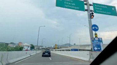 Kalabalık şehir manzarasını gösteren 4K görüntüleri açık bir günde birçok insanın motosiklet sürdüğü ve araba sürdüğü, Bandung, West Java, Endonezya 5 Nisan 2025.