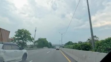 Kalabalık şehir manzarasını gösteren 4K görüntüleri açık bir günde birçok insanın motosiklet sürdüğü ve araba sürdüğü, Bandung, West Java, Endonezya 5 Nisan 2025.