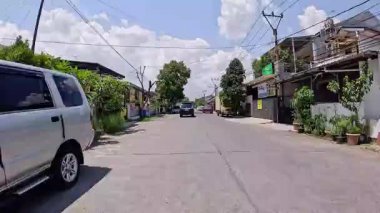 Kalabalık şehir manzarasını gösteren 4K görüntüleri açık bir günde birçok insanın motosiklet sürdüğü ve araba sürdüğü, Bandung, West Java, Endonezya 5 Nisan 2025.