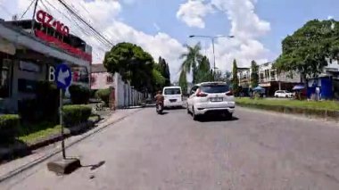 Kalabalık şehir manzarasını gösteren 4K görüntüleri açık bir günde birçok insanın motosiklet sürdüğü ve araba sürdüğü, Bandung, West Java, Endonezya 5 Nisan 2025.