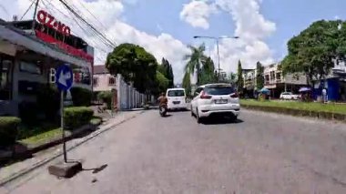 Kalabalık şehir manzarasını gösteren 4K görüntüleri açık bir günde birçok insanın motosiklet sürdüğü ve araba sürdüğü, Bandung, West Java, Endonezya 5 Nisan 2025.