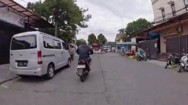 4K sinematik görüntüler Bandung 'un hareketli caddelerini yakalıyor, güneşli bir günde, Bandung, Batı Java, Endonezya 5 Nisan 2025' de, gidip gelen insanları gösteriyor..