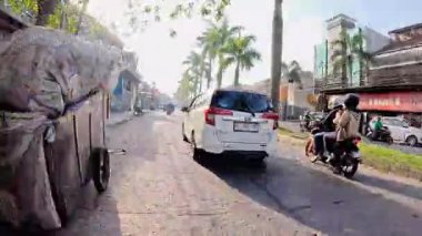 4K sinematik görüntüler Bandung 'un hareketli caddelerini yakalıyor, güneşli bir günde, Bandung, Batı Java, Endonezya 5 Nisan 2025' de, gidip gelen insanları gösteriyor..