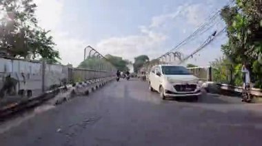 4K sinematik görüntüler Bandung 'un hareketli caddelerini yakalıyor, güneşli bir günde, Bandung, Batı Java, Endonezya 5 Nisan 2025' de, gidip gelen insanları gösteriyor..