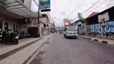 4K sinematik görüntüler Bandung 'un hareketli caddelerini yakalıyor, güneşli bir günde, Bandung, Batı Java, Endonezya 5 Nisan 2025' de, gidip gelen insanları gösteriyor..