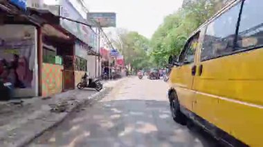 4K sinematik görüntüler Bandung 'un hareketli caddelerini yakalıyor, güneşli bir günde, Bandung, Batı Java, Endonezya 5 Nisan 2025' de, gidip gelen insanları gösteriyor..