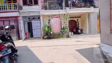 4K sinematik görüntüler Bandung 'un hareketli caddelerini yakalıyor, güneşli bir günde, Bandung, Batı Java, Endonezya 5 Nisan 2025' de, gidip gelen insanları gösteriyor..