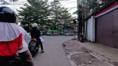 4K sinematik görüntüler Bandung 'un hareketli caddelerini yakalıyor, güneşli bir günde, Bandung, Batı Java, Endonezya 5 Nisan 2025' de, gidip gelen insanları gösteriyor..