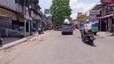 4K sinematik görüntüler Bandung 'un hareketli caddelerini yakalıyor, güneşli bir günde, Bandung, Batı Java, Endonezya 5 Nisan 2025' de, gidip gelen insanları gösteriyor..