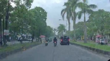 4K sinematik görüntüler Bandung 'un hareketli caddelerini yakalıyor, güneşli bir günde, Bandung, Batı Java, Endonezya 5 Nisan 2025' de, gidip gelen insanları gösteriyor..