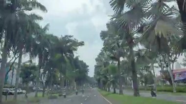 4K sinematik görüntüler Bandung 'un hareketli caddelerini yakalıyor, güneşli bir günde, Bandung, Batı Java, Endonezya 5 Nisan 2025' de, gidip gelen insanları gösteriyor..