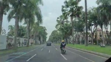 4K sinematik görüntüler Bandung 'un hareketli caddelerini yakalıyor, güneşli bir günde, Bandung, Batı Java, Endonezya 5 Nisan 2025' de, gidip gelen insanları gösteriyor..