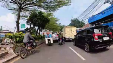 Gün boyunca Bandung sokaklarının 4K görüntüleri ve motosiklet ve araba kullanan insanların faaliyetleri. Bandung, Batı Java, Endonezya 5 Nisan 2025.