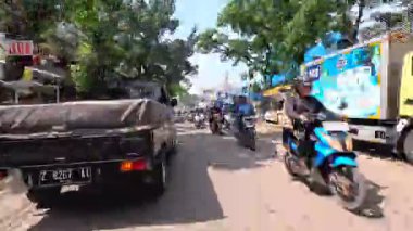 Gün boyunca Bandung sokaklarının 4K görüntüleri ve motosiklet ve araba kullanan insanların faaliyetleri. Bandung, Batı Java, Endonezya 5 Nisan 2025.