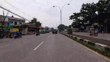 Gün boyunca Bandung sokaklarının 4K görüntüleri ve motosiklet ve araba kullanan insanların faaliyetleri. Bandung, Batı Java, Endonezya 5 Nisan 2025.