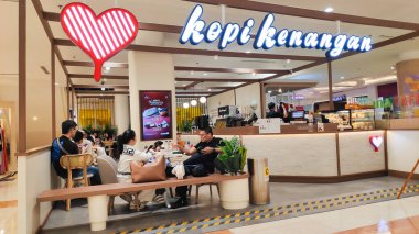 İnsanlar kahve molasında eğleniyor ve alışveriş merkezindeki popüler bir Kopi Kenangan dükkanında içki ısmarlıyorlar. Bandung 21 Haziran 2025