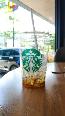 Boş bir Starbucks buzlu kahve fincanının yakın plan fotoğrafı. Bir el tarafından tutulmuş. Bandung 29 Mayıs 2025