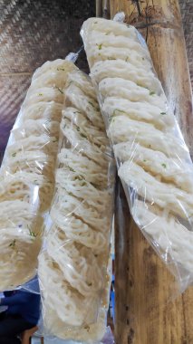 Markette satılık plastik torbalarda asılı çiğ, beyaz, spiral şekilli kerupuk krakerlerinin fotoğrafını kapat..