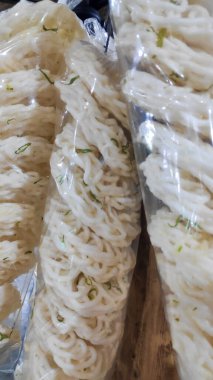 Markette satılık plastik torbalarda asılı çiğ, beyaz, spiral şekilli kerupuk krakerlerinin fotoğrafını kapat..