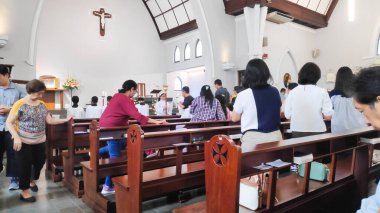 Kilise sıralarında oturan insanlarla dolu bir ayin sırasında modern bir Katolik kilisesinin detaylı bir fotoğrafı. Bandung 7 Aralık 2025