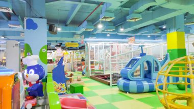 Çocukların ve ebeveynlerin, bir alışveriş merkezinde büyük bir salıncakla gezintiye çıkan canlı bir eğlence parkının keyfini çıkardıkları fotoğraf. Bandung 10 Mayıs 2025