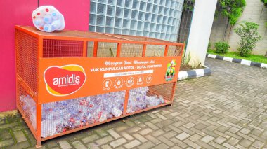Amidis markalı logonun kentsel bir ortamda PET şişeleri topladığı bir geri dönüşüm istasyonunun fotoğrafını çek. Bandung 16 Mayıs 2025