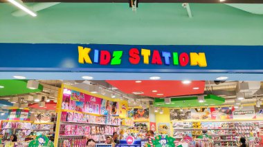 Modern bir alışveriş merkezindeki renkli arka ışıklandırmalı 'KIDZ STATION' mağaza tabelasının fotoğrafını çek. Bandung 19 Haziran 2025