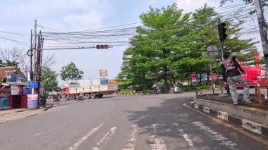 Sinematik 4K zaman tüneli Bandung şehrinin ana caddelerinin hareketli gündüz atmosferini yakalıyor. 5 Nisan 2025 'te Bandung' da motorsiklet ve arabaların yoğun olduğu yoğun trafik, günlük çalışanların yoğun eziyetlerini gözler önüne seriyor..