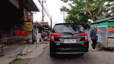 Sinematik 4K zaman tüneli Bandung şehrinin ana caddelerinin hareketli gündüz atmosferini yakalıyor. 5 Nisan 2025 'te Bandung' da motorsiklet ve arabaların yoğun olduğu yoğun trafik, günlük çalışanların yoğun eziyetlerini gözler önüne seriyor..