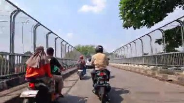 Sinematik 4K zaman tüneli Bandung şehrinin ana caddelerinin hareketli gündüz atmosferini yakalıyor. 5 Nisan 2025 'te Bandung' da motorsiklet ve arabaların yoğun olduğu yoğun trafik, günlük çalışanların yoğun eziyetlerini gözler önüne seriyor..