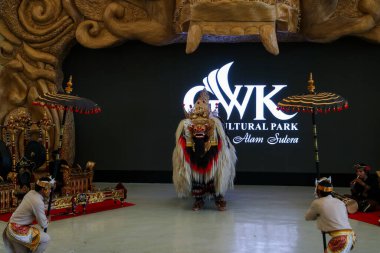 Endonezya, Bali 'de bir sahnede canlı gamelan müziği ve müzisyenlerle geleneksel bir kültürel dans sergileyen bir Balili Barong dansçısının fotoğrafı. Bali, 22 Temmuz 2025.