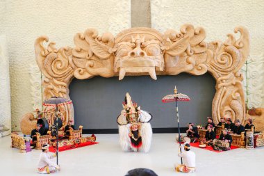 Endonezya, Bali 'de bir sahnede canlı gamelan müziği ve müzisyenlerle geleneksel bir kültürel dans sergileyen bir Balili Barong dansçısının fotoğrafı. Bali, 22 Temmuz 2025.