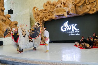Endonezya, Bali 'de bir sahnede canlı gamelan müziği ve müzisyenlerle geleneksel bir kültürel dans sergileyen bir Balili Barong dansçısının fotoğrafı. Bali, 22 Temmuz 2025.