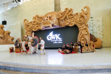 Endonezya, Bali 'de bir sahnede canlı gamelan müziği ve müzisyenlerle geleneksel bir kültürel dans sergileyen bir Balili Barong dansçısının fotoğrafı. Bali, 22 Temmuz 2025.