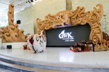 Endonezya, Bali 'de bir sahnede canlı gamelan müziği ve müzisyenlerle geleneksel bir kültürel dans sergileyen bir Balili Barong dansçısının fotoğrafı. Bali, 22 Temmuz 2025.