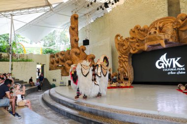 Endonezya, Bali 'de bir sahnede canlı gamelan müziği ve müzisyenlerle geleneksel bir kültürel dans sergileyen bir Balili Barong dansçısının fotoğrafı. Bali, 22 Temmuz 2025.