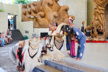 Endonezya, Bali 'de bir sahnede canlı gamelan müziği ve müzisyenlerle geleneksel bir kültürel dans sergileyen bir Balili Barong dansçısının fotoğrafı. Bali, 22 Temmuz 2025.