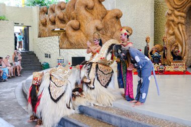 Endonezya, Bali 'de bir sahnede canlı gamelan müziği ve müzisyenlerle geleneksel bir kültürel dans sergileyen bir Balili Barong dansçısının fotoğrafı. Bali, 22 Temmuz 2025.