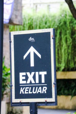 GWK Bali 'deki Beranda Resto ve Amfitiyatrosuna ziyaretçilere rehberlik eden yemyeşil bir bahçe ortamında bir çıkış levhası ve güvenlik kamerası. Bali, 1 Mayıs 2025.