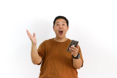 Endonezyalı bir Asyalı beyaz arka planda akıllı telefonunu tutarken avucunun içine bağırıyor..